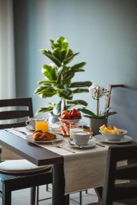 - une table en bois avec des aliments pour le petit-déjeuner dans l'établissement Albergo Commercio, à Palmanova