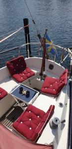 卡爾斯港的住宿－Sailboat Chanel，一条白色的船,在水体上装有红色的座椅