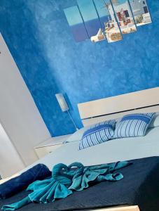 1 dormitorio con 1 cama con paredes azules en B&b Cefalù en Cefalú