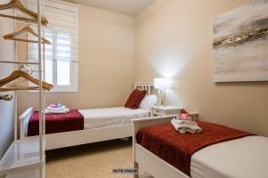 a small bedroom with two beds and a window at Alcam Sant Adria in Sant Adria de Besos