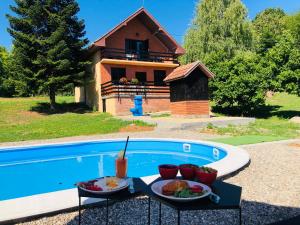 a table with two plates of food next to a pool at Fruska Pool House in Sremska Kamenica