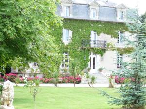 a large white house with ivy on it at Manoir de la Marjolaine in Cabourg