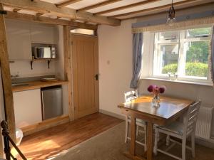 cocina y comedor con mesa de madera en Newton Farmhouse, en Whiteparish