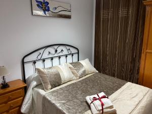 a bedroom with a bed with a christmas bow on it at Vivienda Rural Los Tajos de Setenil in Setenil