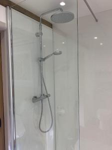 a shower with a glass door in a bathroom at Newton Farmhouse in Whiteparish