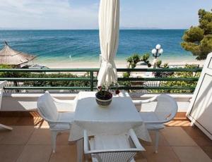 een tafel en stoelen op een balkon met uitzicht op de oceaan bij BEACH APARTMENT in Podgora