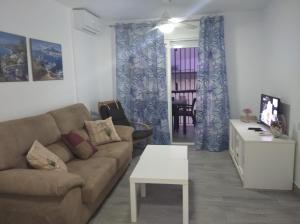 a living room with a couch and a table at Apartamento La Gaviota in Chipiona