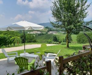 un patio con mesa, sillas y sombrilla en La Casetta en Vittorio Veneto