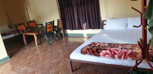 - une chambre avec un lit, une table et des chaises dans l'établissement Elephant Garden Hotel and Resort Pvt Ltd, à Kanchanpur