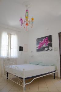 1 dormitorio con 1 cama con lámpara de araña en A casa di Rio, en Lecce