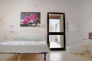 1 dormitorio con cama, espejo y silla en A casa di Rio, en Lecce