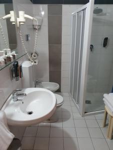 a bathroom with a toilet, sink, and shower at Hotel San Giorgio in Bergamo