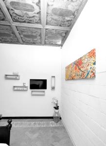 Habitación con una pintura en la pared y TV. en La Bosca agriturismo, en Gavardo