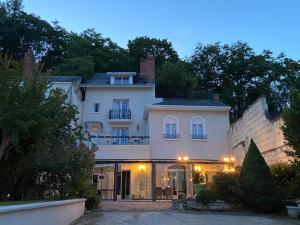 a large white house with a balcony on top of it at Les Rives du Cher - Chambres d'hôtes in Montrichard