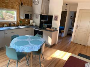 a kitchen with a table and chairs in a kitchen at GITE CHALET BOIS in Bessuéjouls