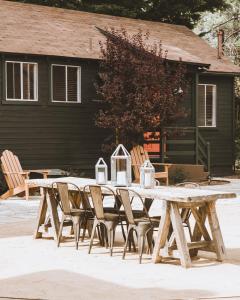 a wooden picnic table and chairs in front of a house at Noon Lodge in Big Bear Lake