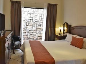 a hotel room with a bed and a window at Hotel Sand´s San Luis in San Luis Potosí