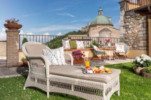 a wicker chair with a tray of food on a patio at Hotel Ideale in Assisi
