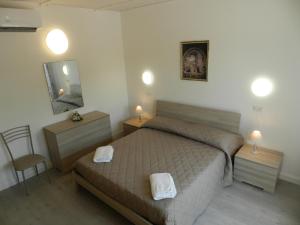 a bedroom with a bed and two tables and a mirror at Appartamenti Via Cortonese 1 in Perugia
