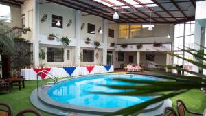 a large swimming pool in a building with a table at Hotel Pensión Bonifaz in Quetzaltenango