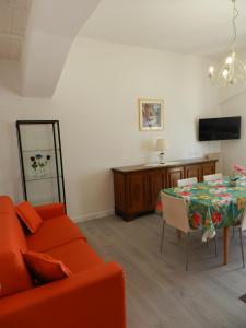 a living room with a orange couch and a table at Appartamenti Via Cortonese 1 in Perugia
