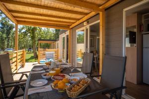 een tafel met eten op een patio bij Eurocamp Mobile Homes at Campsite Park Umag in Umag