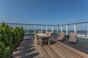 a patio with a table and chairs on a balcony at Modern spacious studio w/ Sea Views in Klaipėda