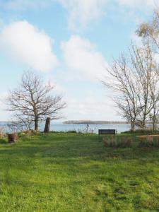 a grassy field with two benches in front of the water at Apartments Sonne am Sund in Stralsund