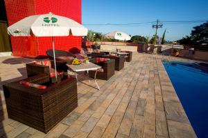 a hotel with an umbrella and tables and a pool at Hotel Dan Inn Campinas Anhanguera - By Nacional Inn in Campinas