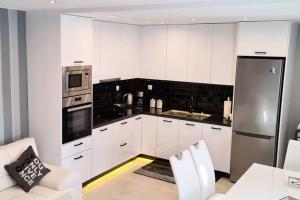a kitchen with white cabinets and a stainless steel refrigerator at Villa Marmari 3 in Marmari