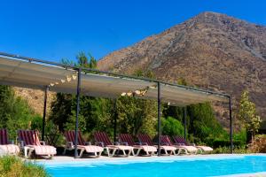 a group of chairs under a canopy next to a swimming pool at Lodge del Maipo in San José de Maipo