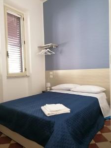 a bedroom with a blue bed with two towels on it at Barlaam 3 in Reggio di Calabria