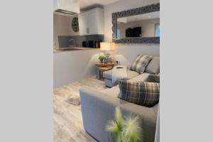 a living room with a couch and a table at Luxury five star cottage one in Tantobie