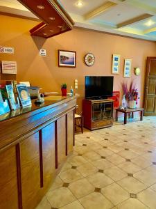 a large room with a counter with a television at Alexandra Hotel in Kalamaki