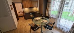 una mesa y sillas en una cocina con mesa y ventana en Apartment Sunshine, en Saas-Grund