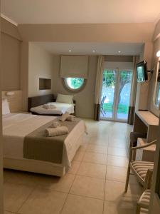 a hotel room with two beds and a television at Nostos Hotel in Afitos