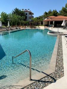 uma piscina com água azul num resort em Nostos Hotel em Afitos