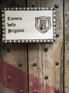 un letrero en una puerta de madera que lee la puerta del jardín episcopal en Agriturismo Castello Di Belforte, en Todi