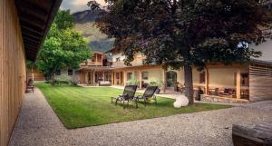 una casa con un patio con sillas y un árbol en Pension Moarhof, en Campo Tures