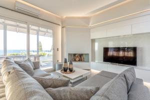 a living room with a couch and a tv at Queen's Gem Luxury Villa - Heated Jacuzzi & Pool in Hersonissos