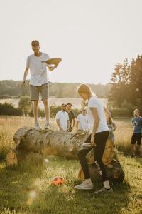 Eine Gruppe von Menschen, die auf einem Logbuch mit einem Fußballball stehen in der Unterkunft Hotel Zur Burg Sternberg in Extertal