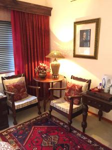 a living room with two chairs and a table at The Crown Guest House in Bethlehem