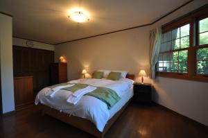 a bedroom with a large bed and two lamps at Creek House Hakuba - Vacation STAY 87290 in Hakuba