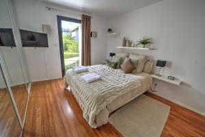 1 dormitorio con cama y ventana grande en La Grange Emnitan - Maison de ville moderne pour 12p Fêtes interdites, en Saint-Genis-Pouilly