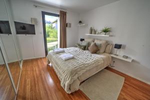 ein Schlafzimmer mit einem Bett und einem großen Fenster in der Unterkunft La Grange Emnitan - Maison de ville moderne pour 12p Fêtes interdites in Saint-Genis-Pouilly