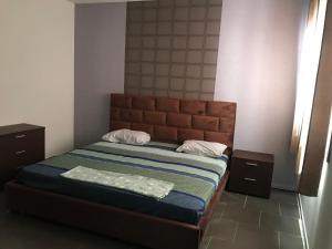 a bedroom with a bed and two night stands at Too Many Suites in Saidia 