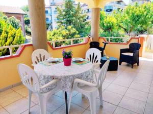 una mesa blanca y sillas en un balcón con mesa y sillón en Villetta a Trebisacce con vista mare en Trebisacce