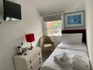 a bedroom with a bed and a tv and a chair at The Mountview in Scarborough
