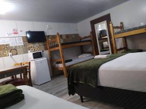 Habitación de hotel con 2 camas y TV en Pousada Do Galdino, en Blumenau