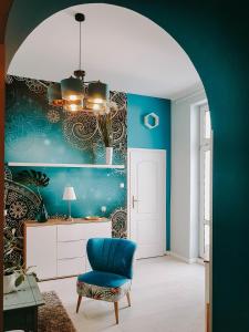 伊諾弗羅茨瓦夫的住宿－Strefa Solanki，客厅拥有蓝色的墙壁和蓝色的椅子